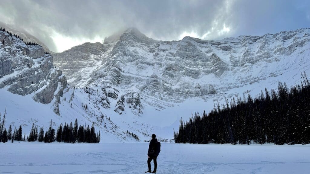 Standing on the frozen Rawson Lake Kananaskis with snow-covered Mount Sarrail close by
