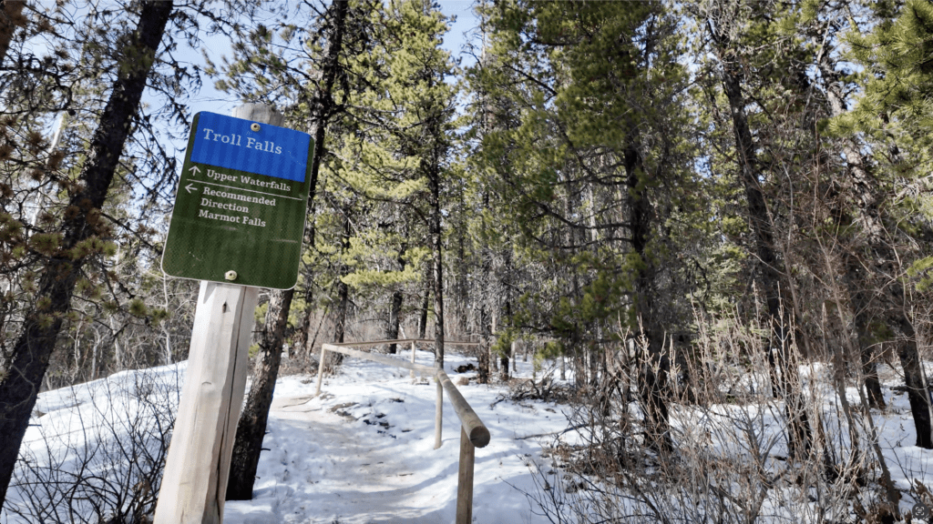 A sign showing the diverging path which turn left to the recommended direction to Marmot Falls and turn right to Upper Falls in Kananaskis