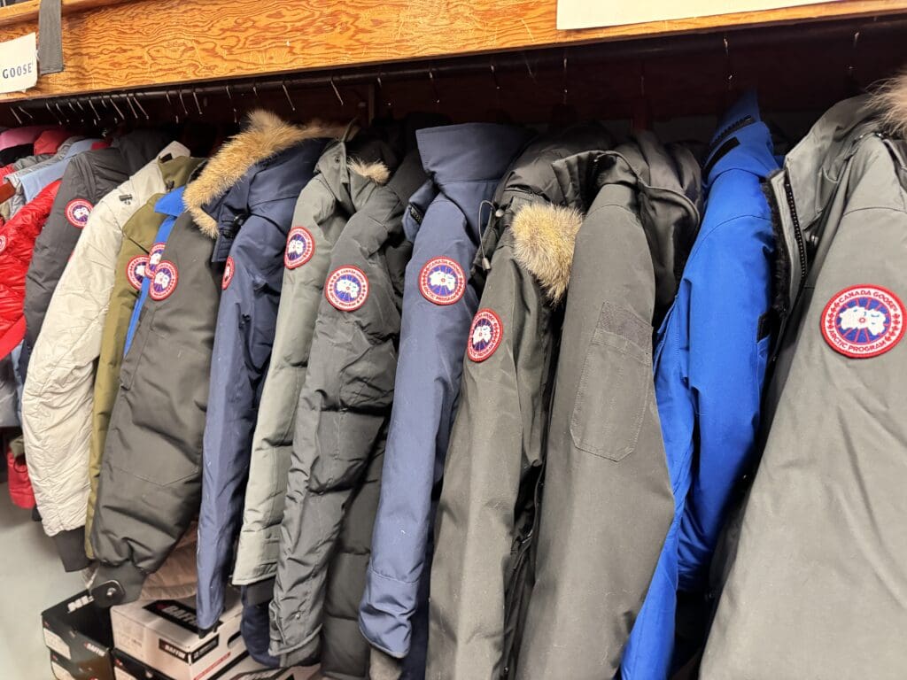 A shelf of Canada Goose insulated parka selling in Weaver & Devore Trading in Old Town Yellowknife for Extreme cold weather gear.