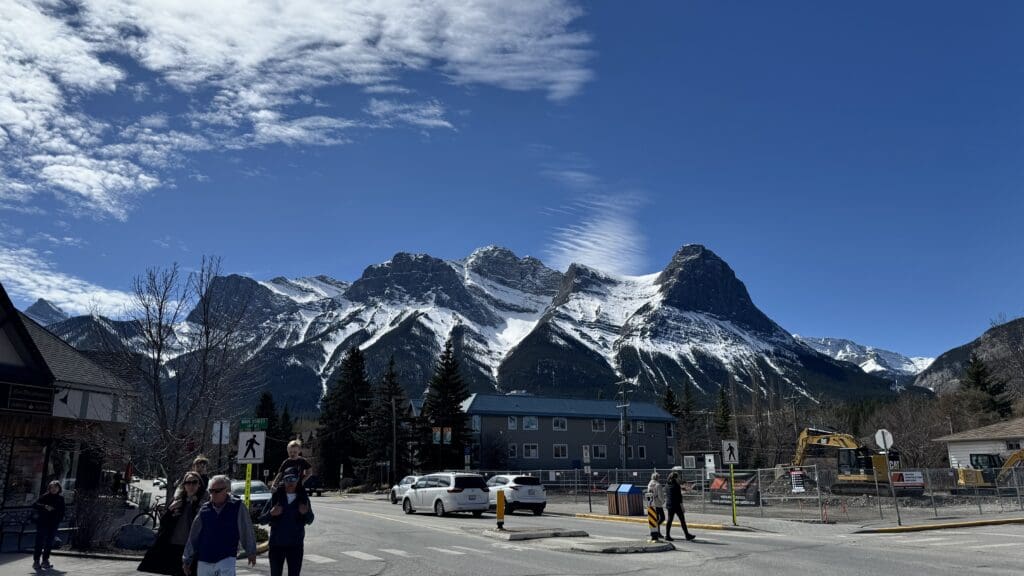 Scenic view of Ha Ling Peak and Mount Lawrence Grassi with snow-capped summits under a clear blue sky, seen from downtown Canmore, Alberta