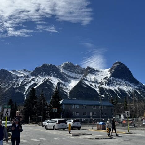 Scenic view of Ha Ling Peak and Mount Lawrence Grassi with snow-capped summits under a clear blue sky, seen from downtown Canmore, Alberta