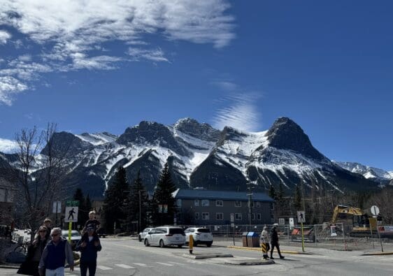 Scenic view of Ha Ling Peak and Mount Lawrence Grassi with snow-capped summits under a clear blue sky, seen from downtown Canmore, Alberta