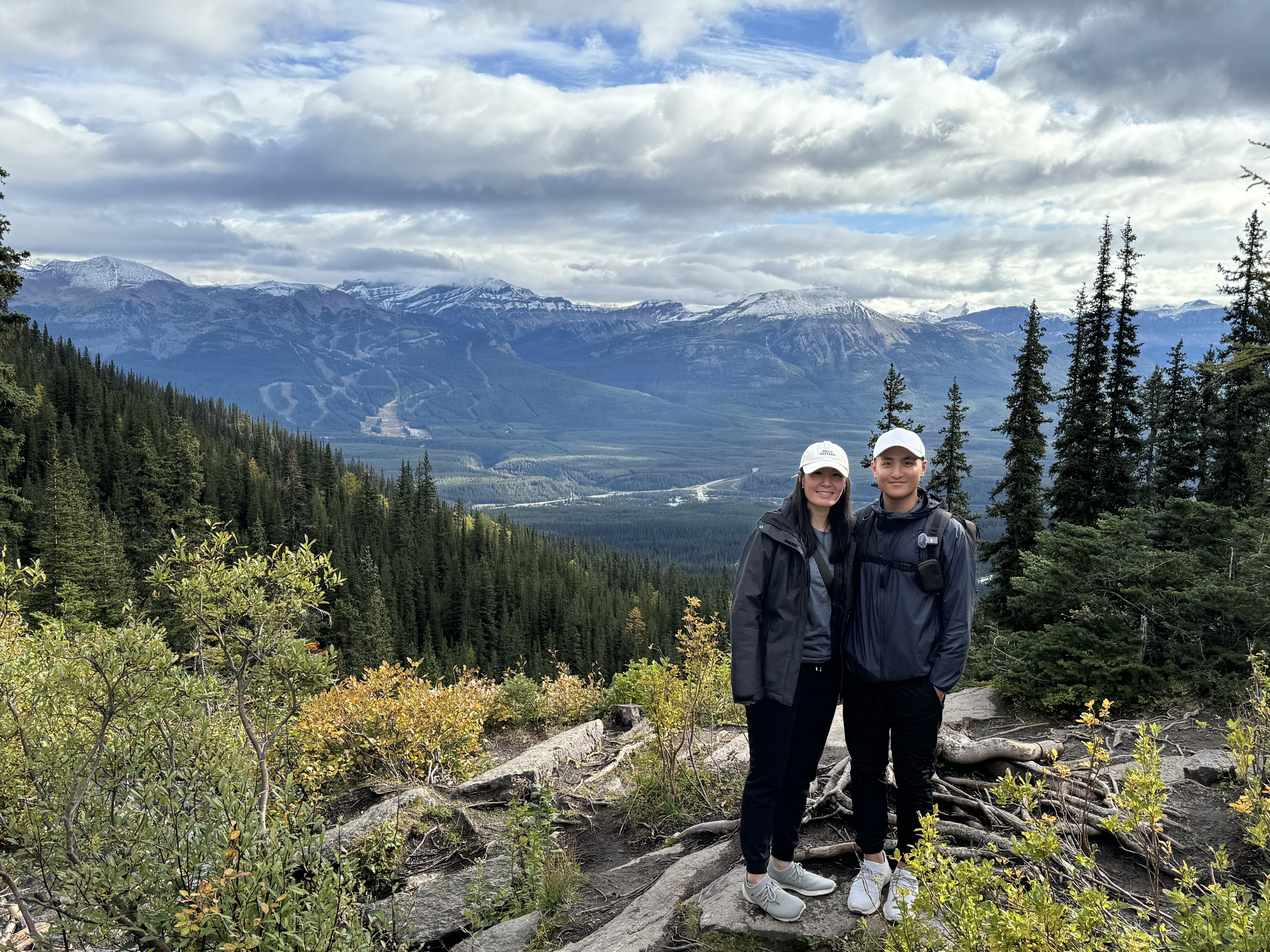Michelle & Evan at a scenic spot in Lake Agnes in Banff National Park with a range of Rocky Mountains at the back