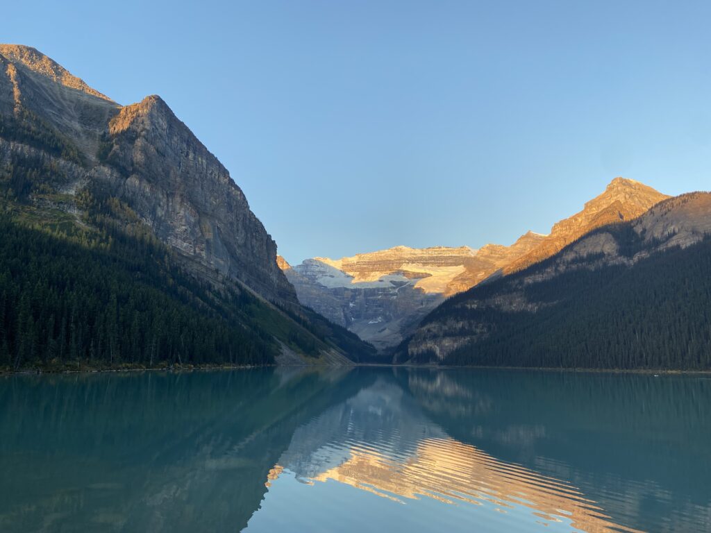 Beautiful sunrise at Lake Louise with calm water showing sky reflection
