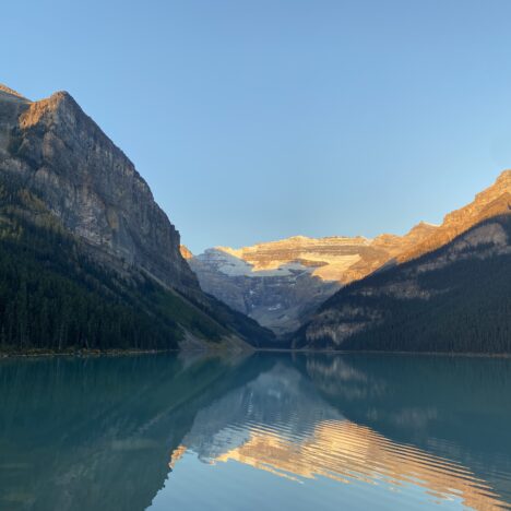 Beautiful sunrise at Lake Louise with calm water showing sky reflection