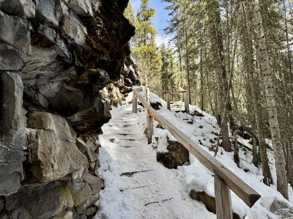 A snow-covered steep wooden stairs from Marmot Falls to Upper Falls in Kananaskis