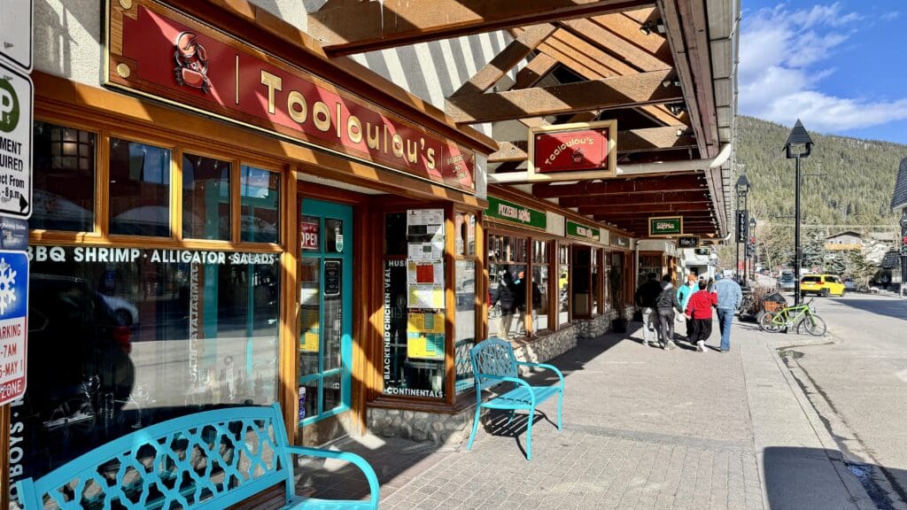 Tooloulou’s is a restaurant next to Banff Avenue with colorful design and two light blue benches placed at the front of the restaurant