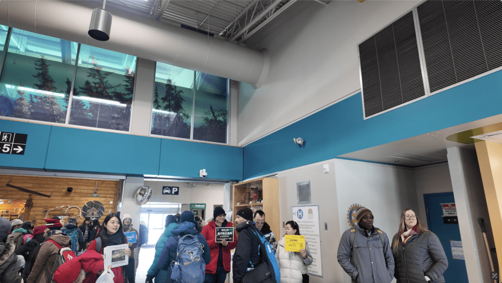 Many tour guides raising their welcoming sign and waiting at the Yellowknife Airport